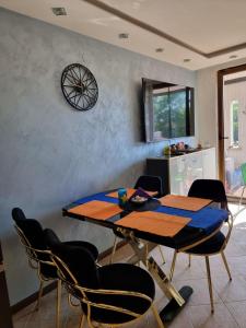 洛泽内茨Oazis resort lux vip apartament的餐桌、椅子和墙上的时钟