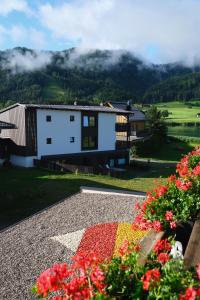 魏森湖See Hotel Kärntnerhof- das Seehotel am Weissensee!的山中一座有鲜花的房屋