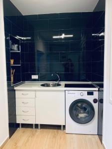 蓬塔翁布里亚Apartamento Delfin - Punta Umbria的厨房配有水槽和洗衣机