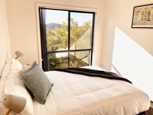 圣海伦斯Bays Rest的一间卧室设有一张床和一个大窗户