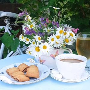 比哈奇Holiday Home Casa Rondo的桌上的咖啡和饼干,配上鲜花