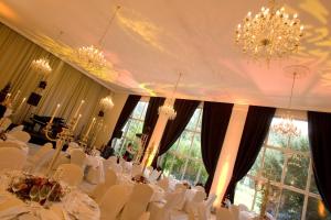 特里尔尼尔斯公园酒店的一间配备有白色桌椅和吊灯的餐厅