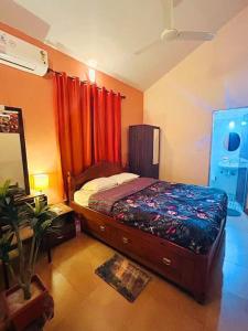 Arossim-CansaulimReev's Homestay: Luxury 2 Bedroom apartment的一间卧室配有红色窗帘的床