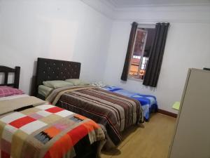 利马EL SEÑORIAL的一间卧室设有两张床和窗户。