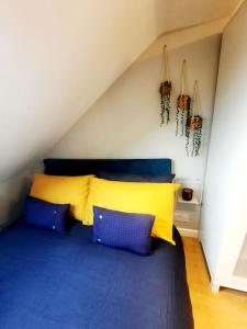 伦敦Alross studio flat / private bathroom的一间卧室配有蓝色和黄色枕头的床