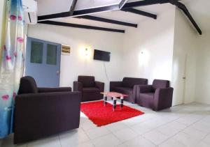 NausoriMohans Apartments的客厅配有两张沙发和红色地毯
