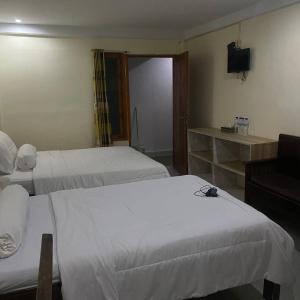 纳闽巴霍Pesona Room and restaurant的酒店客房设有两张床和电视。