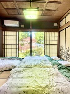 富士吉田市T&T Fujiyama Guest House的一张大床,位于带大窗户的房间里
