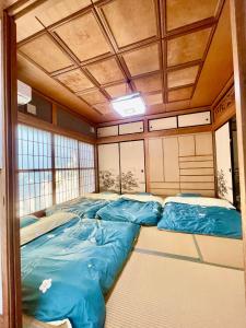 富士吉田市T&T Fujiyama Guest House的一间房间,里面装有四个蓝色睡袋