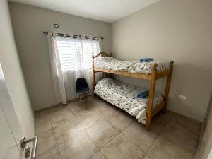 瓜伊马延Mendoza Deptos apart的一间卧室设有两张双层床和一扇窗户。