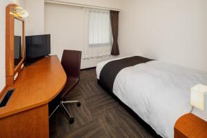 熊本熊本东急REI酒店的配有一张床和一张书桌的酒店客房