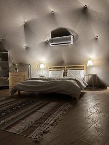 Rahwat al BarrAlbaha domes的一间卧室配有一张大床和两盏灯。