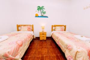 帕拉卡斯Hospedaje Mary的一间卧室设有两张床,铺有木地板