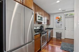 华盛顿Perfect Location! Stylish Condo Steps Away from Nationals Stadium and Navy Yard in DC's Southwest Gem的厨房配有不锈钢冰箱和木制橱柜