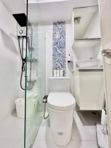 曼达维市Queen Size Studio in Cebu City的白色的浴室设有卫生间和淋浴。