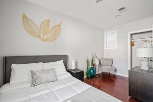 华盛顿Perfect Location! Stylish Condo Steps Away from Nationals Stadium and Navy Yard in DC's Southwest Gem的卧室配有白色床,墙上挂着蝴蝶