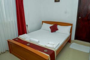亭可马里维拉酒店的一张小床,位于一个红色窗帘的房间
