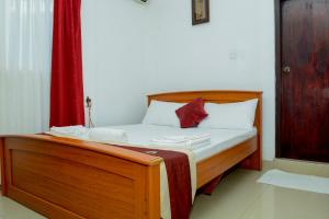 亭可马里维拉酒店的一张铺有白色床单和红色窗帘的床