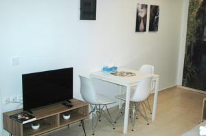 ApolpainaA L' AISE STUDIOS的客厅配有桌椅和电视