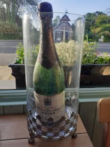 奥贝尔维尔Ma Campagne - Le Jardin的一张桌子上放一瓶葡萄酒