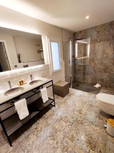 莱斯卡拉Taverna de la Sal Boutique Hotel的浴室配有2个盥洗盆、卫生间和淋浴。