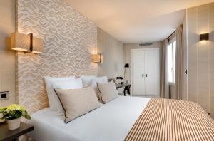 巴黎乐瑟纳酒店的卧室配有带枕头的大型白色床