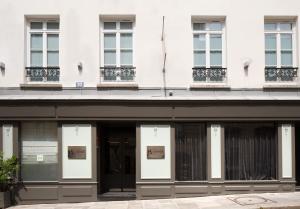 巴黎乐瑟纳酒店的白色建筑的外墙,带有窗户