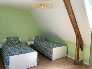 Poullan-sur-MerGîte de Kermoal-location de vacances的配有绿墙和吊灯的客房内的两张床