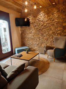 莱斯卡拉Taverna de la Sal Boutique Hotel的带沙发和桌子的客厅以及石墙