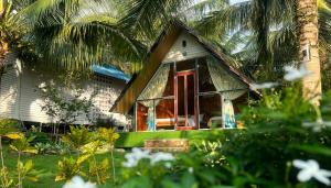 富国Phu Nam House - Resort的一座红色门和棕榈树的房子