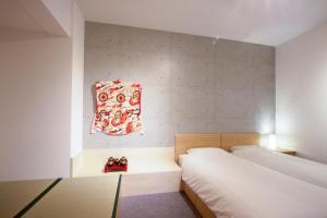 京都スイートステイ京都 Suite Stay Kyoto的一间小卧室,配有两张床和一张桌子