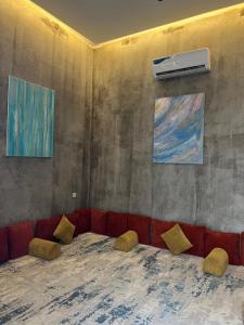 Al Kuraشاليهات كورال بارك的客厅配有红色沙发和两幅画作