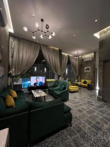 Al Kuraشاليهات كورال بارك的客厅配有绿色沙发和平面电视