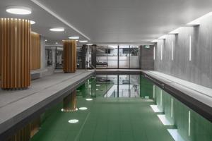墨尔本Samma Flagstaff Luxury Apartments的游泳池,设有绿色的地板和黄色的柱子