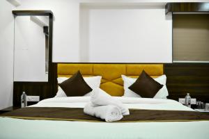 艾哈迈达巴德Hotel Royal Ican Sindhu Bhavan Road的一张大床,上面有白色毛巾