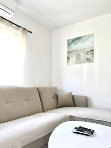 赫尔采格诺维Apartman Misovic的带沙发的客厅和遥控器