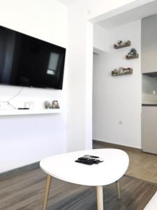 赫尔采格诺维Apartman Misovic的客厅设有一张白色咖啡桌,配有电视。