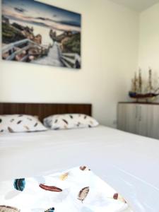 赫尔采格诺维Apartman Misovic的一张带两个枕头的床和一张墙上的照片