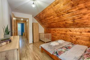 索利纳Chaty na Skalistym Wzgórzu的一间卧室设有木墙和一张床