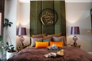 清迈THE NINE THASALA的一间卧室配有一张带大型绿色床头板的床