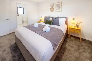 基督城Modern Comforts 2 bed 2 bath Inner City的卧室配有带毛巾的大型白色床