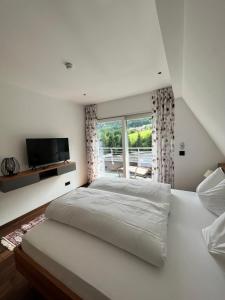 圣吉尔根霍威格酒店的白色的卧室设有一张大床和一个窗户