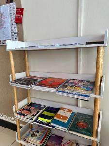 乔治市Swing & Pillows @ Malabar的书架上装有杂志和书籍