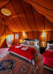 梅尔祖卡Merzouga Top Luxury Camp的帐篷内一间卧室,配有一张床