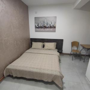 索科矿泉村Studia ANIKS的卧室配有一张床,墙上挂有绘画作品