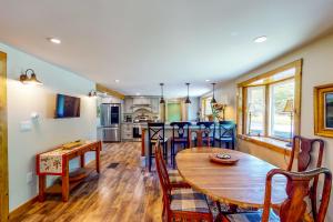 Coos Canyon Lodge的厨房以及带木桌和椅子的客厅。