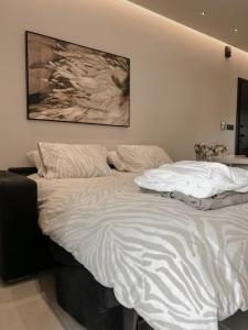 拉格尼西Lagonisi Luxury Apartment by the sea的卧室内的一张白色床,墙上挂着一幅画