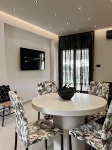 拉格尼西Lagonisi Luxury Apartment by the sea的一间配备有白色桌椅的用餐室