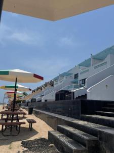 杜拉特阿拉尔درة العروس استوديو على شاطئ البرادايس - عوائل的一座带楼梯、野餐桌和雨伞的建筑