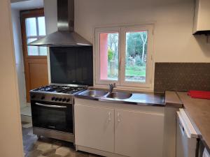卡尔卡松Carignan的厨房配有水槽、炉灶和窗户。